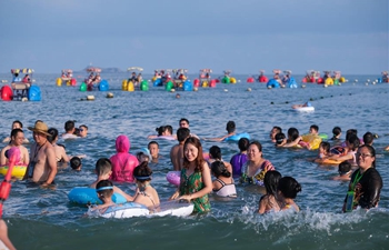 Tourists enjoy leisure time at Zhujiajian scenic spot in Zhoushan City, Zhejiang Province