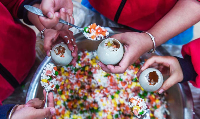 Children make traditional food to greet light snow in east China