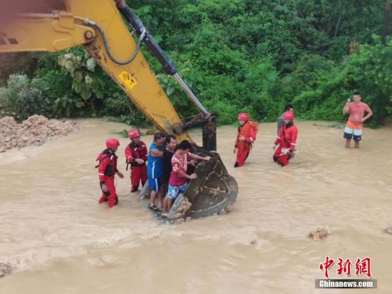 6月16日，因遭遇暴雨袭击，广西沿海多处发生严重内涝，居民被困。当地消防部门接到求助信息后，先后转移被困的居民数十人。图为利用铲车运送被困居民。